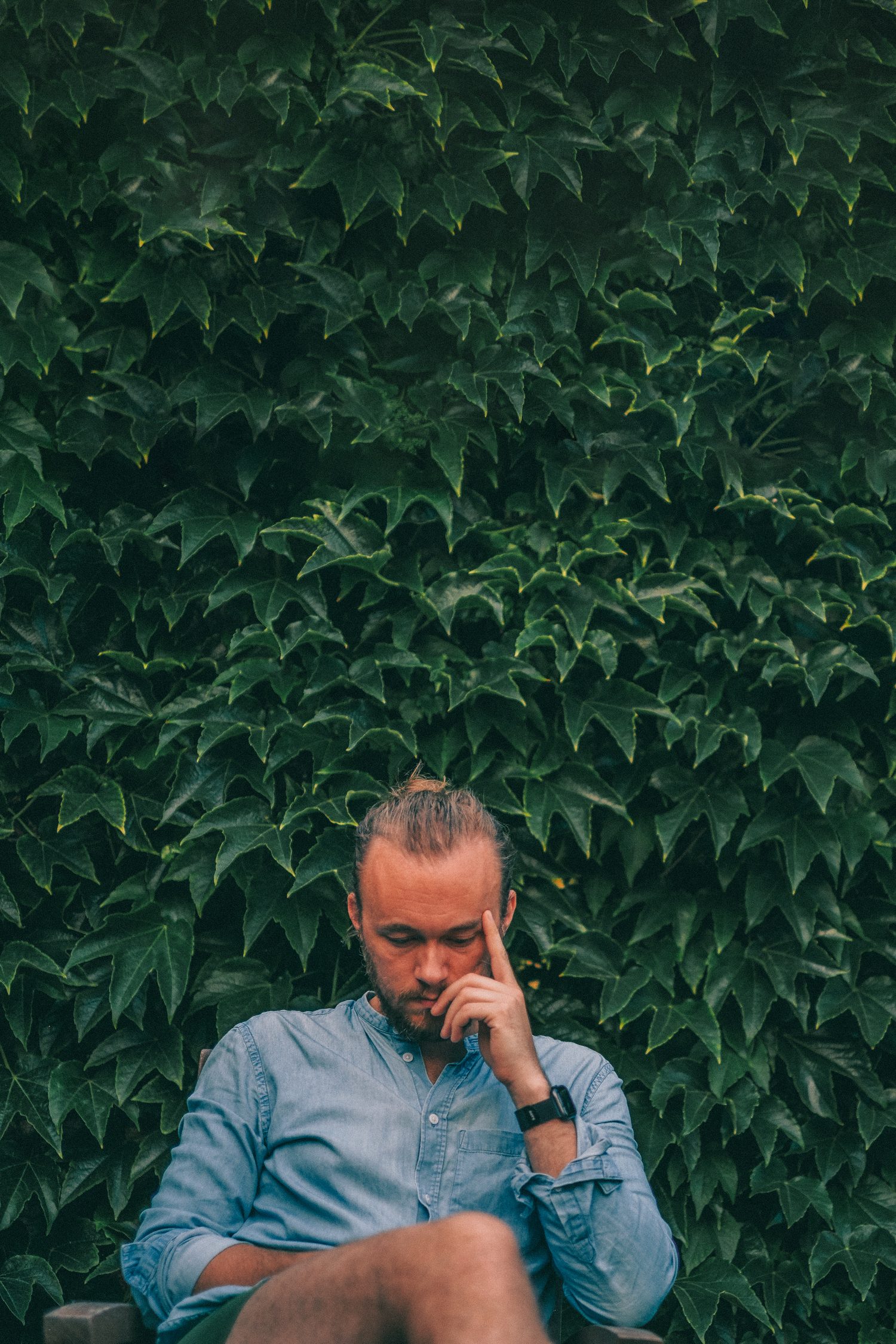 Rasmus Fritzon sitting in front of an ivy-covered wall